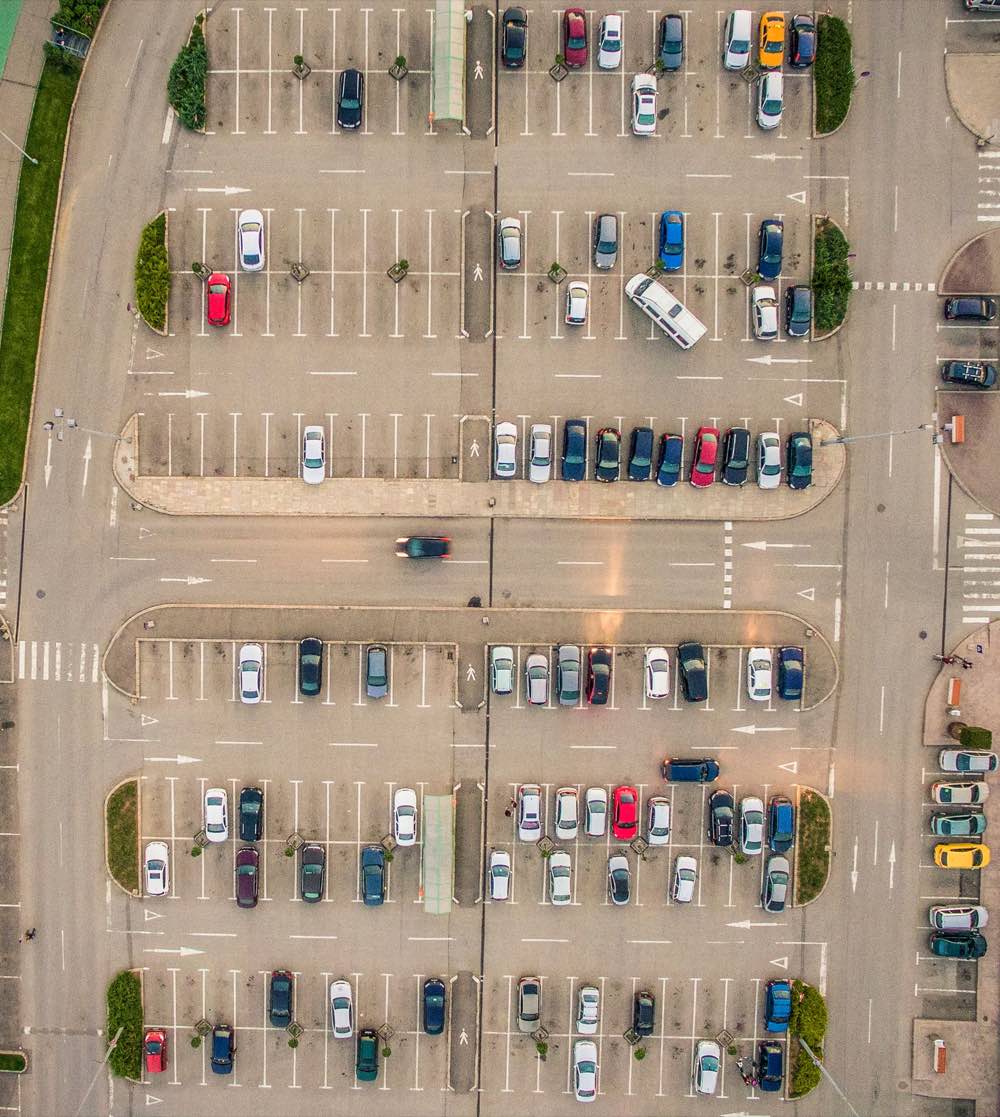 Aerial view of a large car park with marked bays, aisles and pedestrian crossings